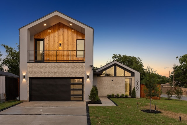 modern home with concrete driveway, an attached garage, a balcony, and a front lawn