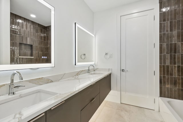 bathroom featuring tile patterned flooring, vanity, and tiled shower / bath