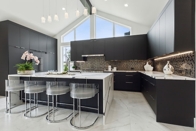 kitchen with backsplash, a large island, plenty of natural light, and hanging light fixtures