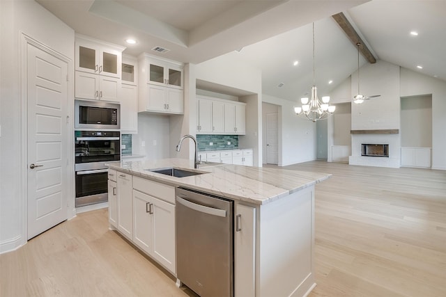 kitchen featuring light hardwood / wood-style floors, white cabinetry, a center island with sink, and appliances with stainless steel finishes