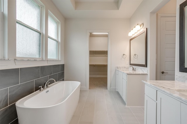 bathroom with tile patterned flooring, vanity, and a tub to relax in