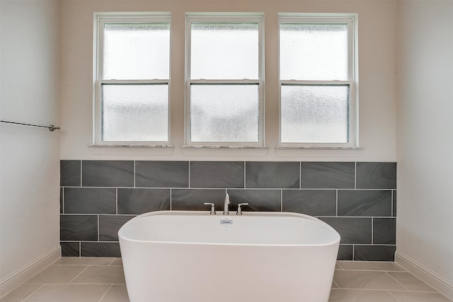 bathroom with tile walls, a tub to relax in, and tile patterned floors