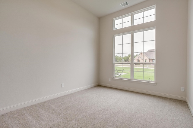 unfurnished room featuring carpet and plenty of natural light