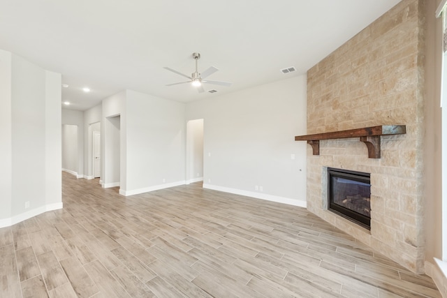 unfurnished living room with light hardwood / wood-style floors, a fireplace, and ceiling fan