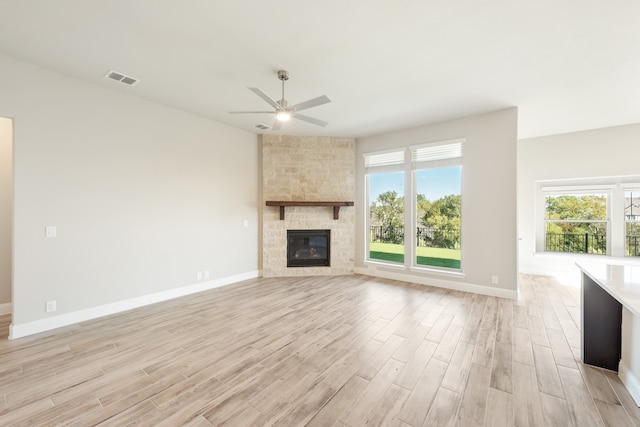 unfurnished living room featuring light hardwood / wood-style floors, a fireplace, and ceiling fan