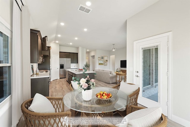 dining area with ceiling fan and light hardwood / wood-style flooring