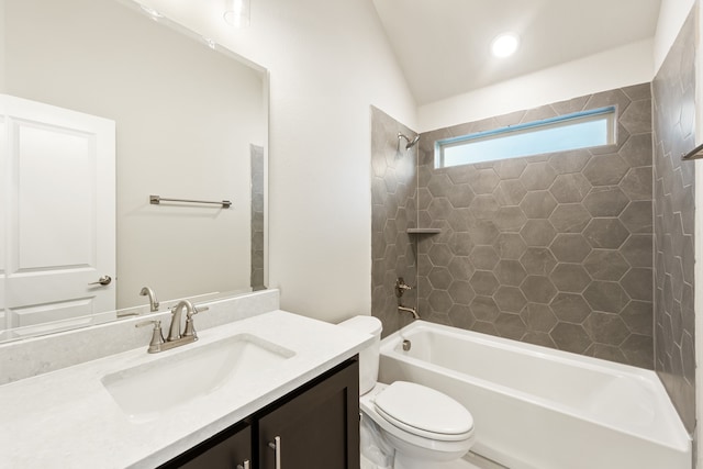 full bathroom with vanity, toilet, tiled shower / bath combo, and vaulted ceiling