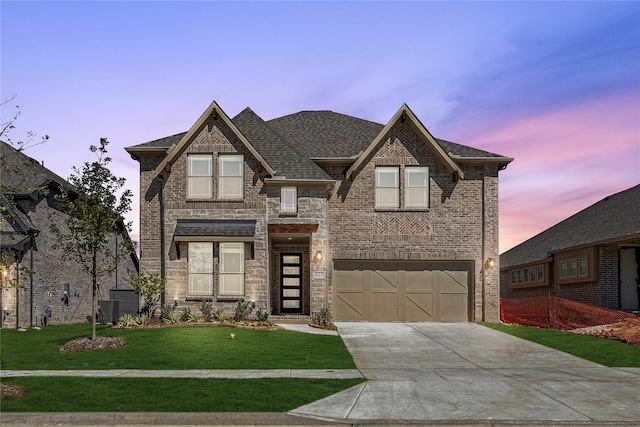 view of front of property featuring a garage and a lawn