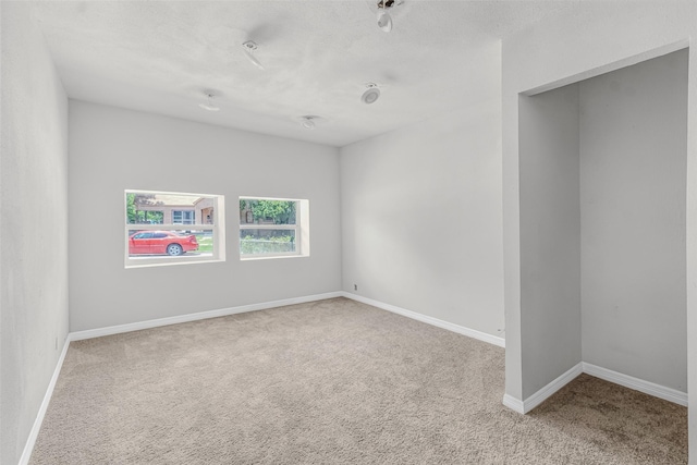 unfurnished room featuring light carpet