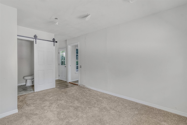 carpeted spare room with a barn door