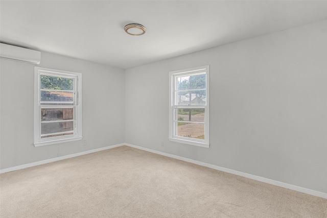 empty room with light carpet, a wall mounted air conditioner, and a healthy amount of sunlight