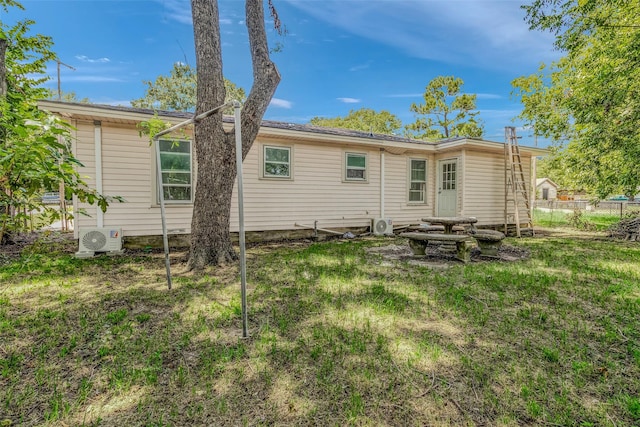 back of property with a yard and ac unit