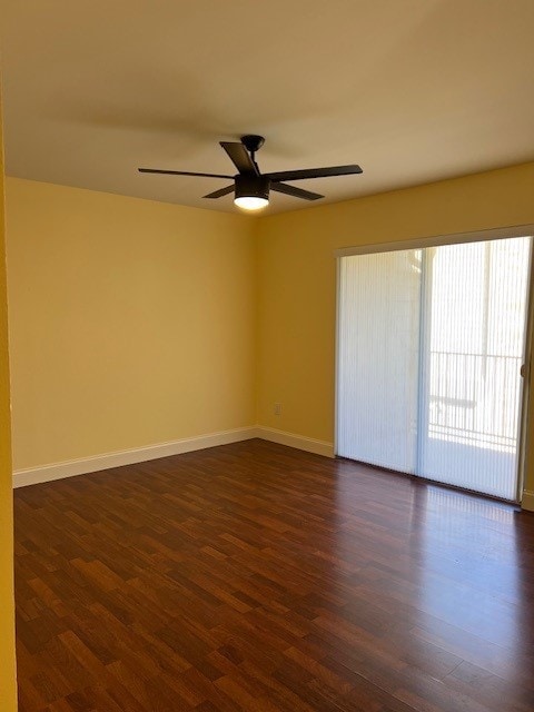 spare room with ceiling fan and dark wood-type flooring