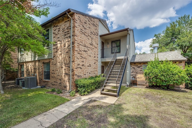 view of front of home with a front lawn, stairway, and brick siding