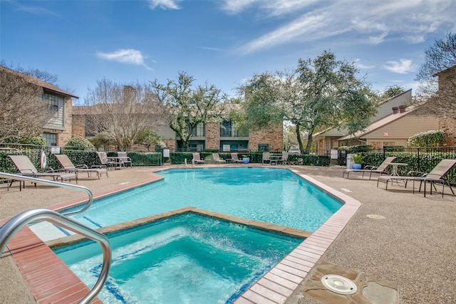 community pool with a patio, a community hot tub, and fence