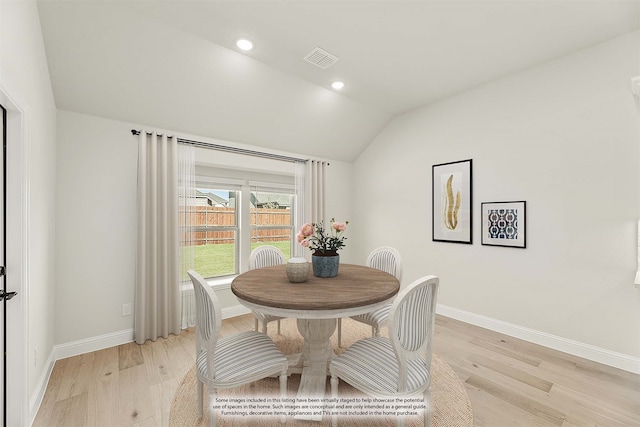 dining room featuring lofted ceiling and light wood-type flooring