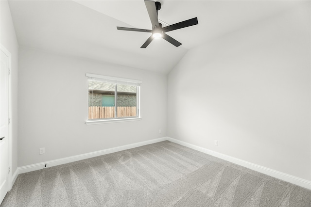 empty room with ceiling fan, carpet flooring, and vaulted ceiling