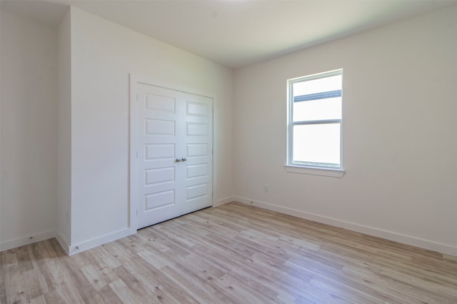 unfurnished bedroom featuring a closet and light wood-type flooring