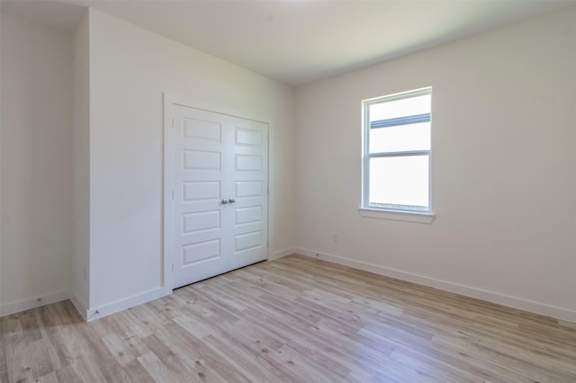 unfurnished bedroom with baseboards and light wood finished floors