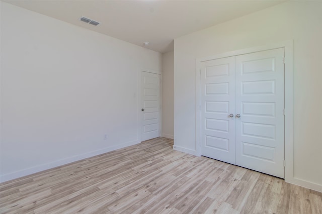 unfurnished bedroom featuring light hardwood / wood-style floors and a closet