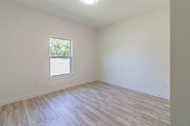 unfurnished room featuring baseboards and light wood finished floors