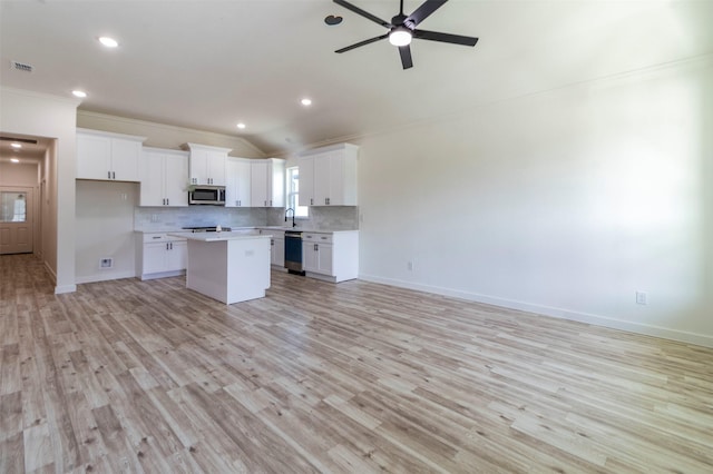 kitchen with visible vents, decorative backsplash, stainless steel microwave, open floor plan, and dishwashing machine