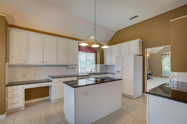 kitchen with white refrigerator with ice dispenser, light tile patterned floors, white cabinets, a kitchen island, and lofted ceiling