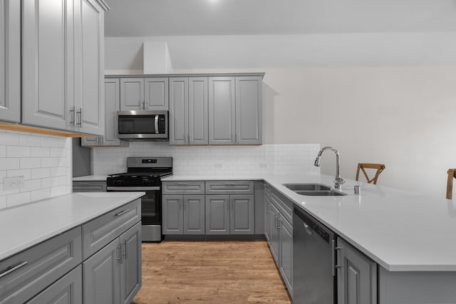 kitchen with gray cabinetry, sink, and appliances with stainless steel finishes