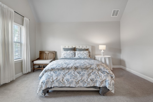 bedroom featuring light carpet and vaulted ceiling