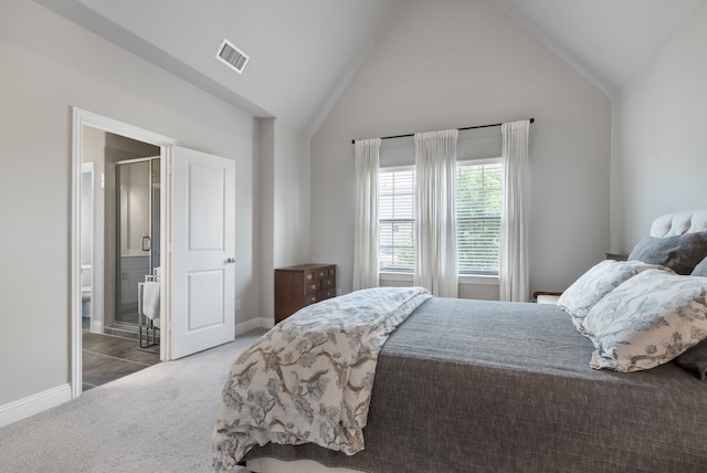 bedroom with dark colored carpet, connected bathroom, and vaulted ceiling