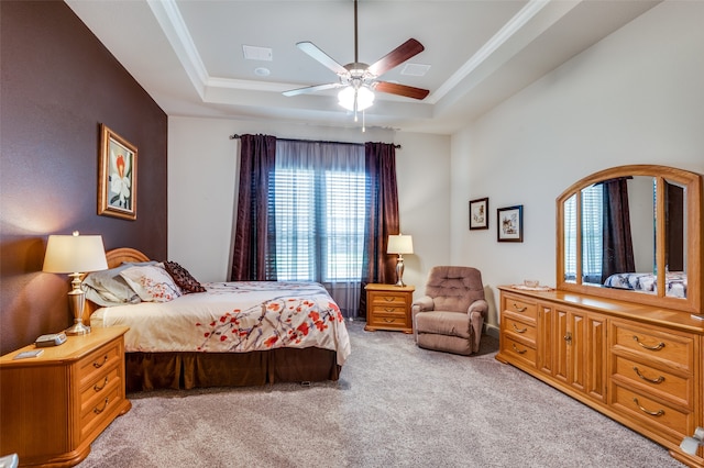 bedroom featuring ceiling fan, ornamental molding, a raised ceiling, and light colored carpet