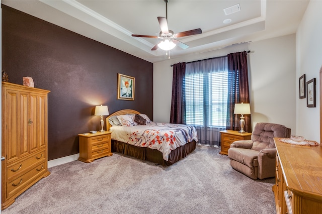 bedroom featuring a raised ceiling, ornamental molding, carpet, and ceiling fan