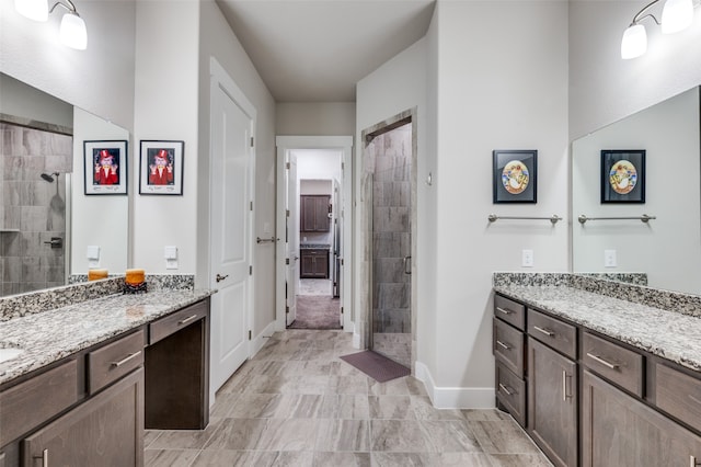 bathroom with a tile shower and vanity