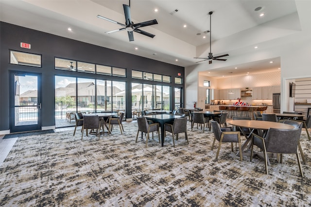 dining room with ceiling fan and a high ceiling