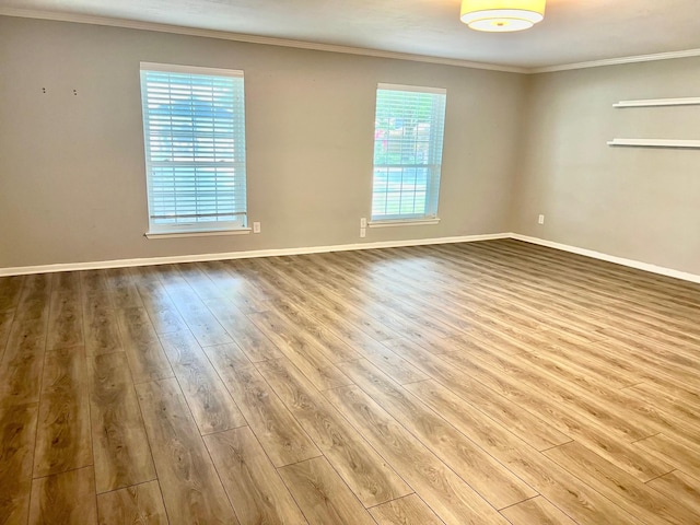 spare room with plenty of natural light, light hardwood / wood-style flooring, and ornamental molding