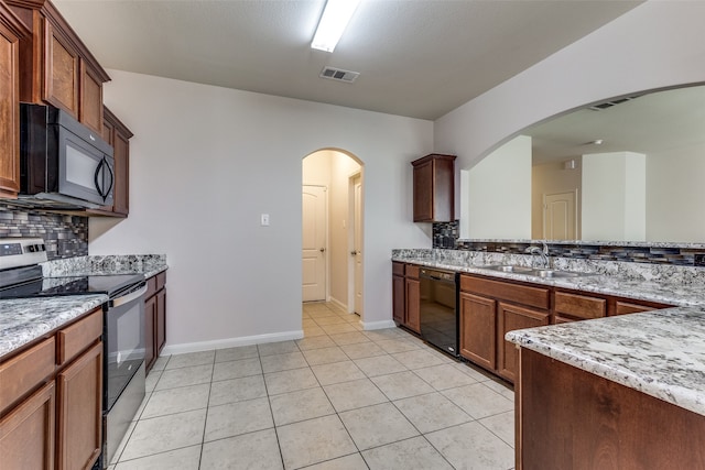 kitchen with light stone countertops, backsplash, sink, black appliances, and light tile patterned floors