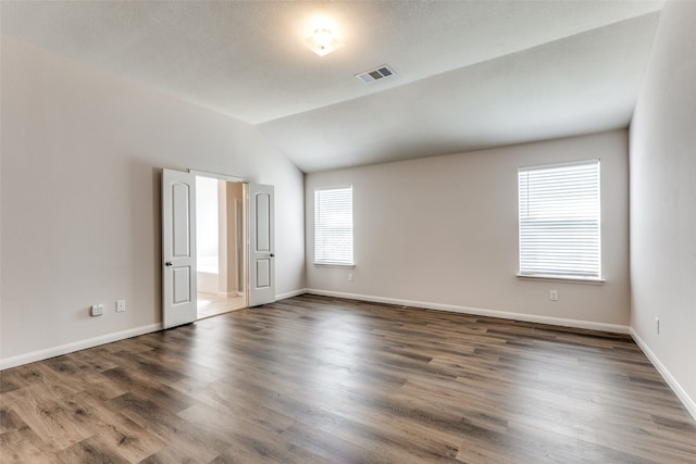 empty room featuring dark hardwood / wood-style flooring and lofted ceiling