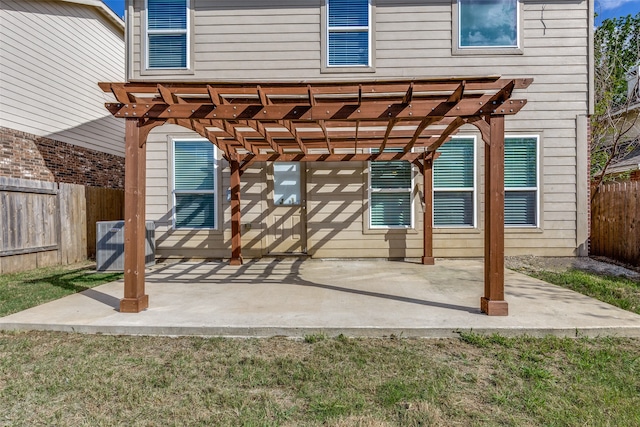 back of property with a lawn, a patio area, a pergola, and central AC