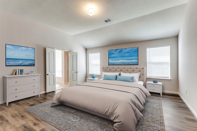 bedroom with wood-type flooring, multiple windows, and lofted ceiling