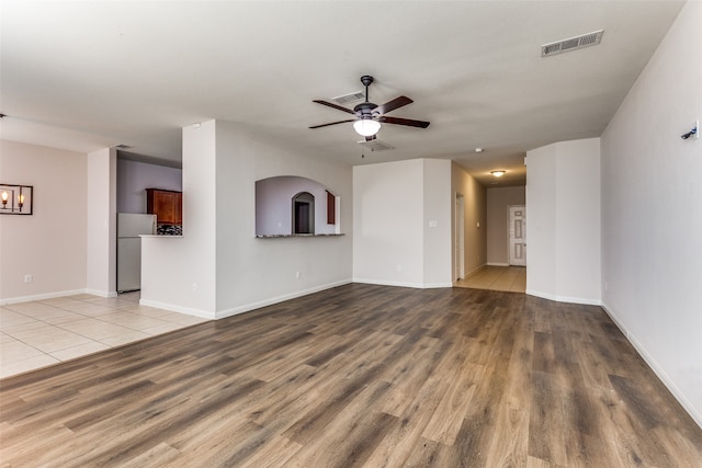 unfurnished living room featuring ceiling fan and light hardwood / wood-style flooring