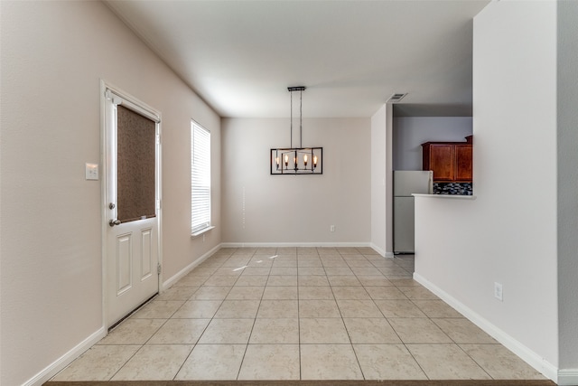 unfurnished dining area featuring light tile patterned floors and an inviting chandelier