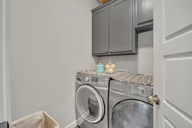 laundry room with washer and dryer and cabinets