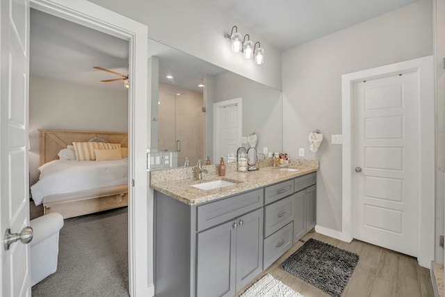 bathroom with vanity, an enclosed shower, hardwood / wood-style flooring, and ceiling fan