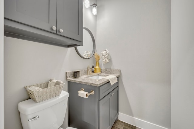 bathroom with toilet, vanity, and wood-type flooring