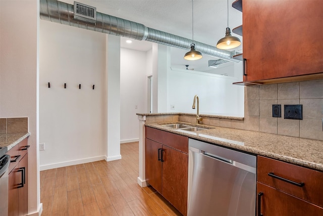 kitchen with appliances with stainless steel finishes, hanging light fixtures, light hardwood / wood-style floors, light stone counters, and sink