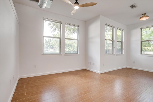 empty room with ceiling fan, light wood-type flooring, and plenty of natural light