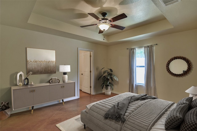 bedroom featuring a raised ceiling and ceiling fan