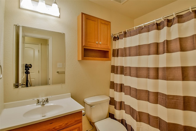 bathroom featuring a shower with curtain, vanity, and toilet