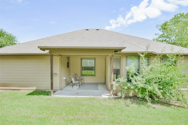 rear view of house with a yard and a patio