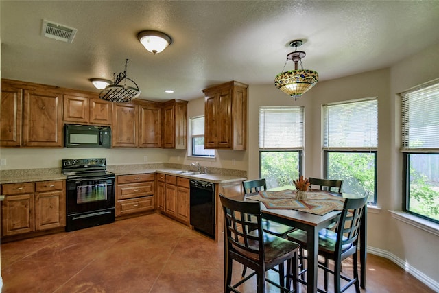 kitchen with sink, hanging light fixtures, a healthy amount of sunlight, and black appliances